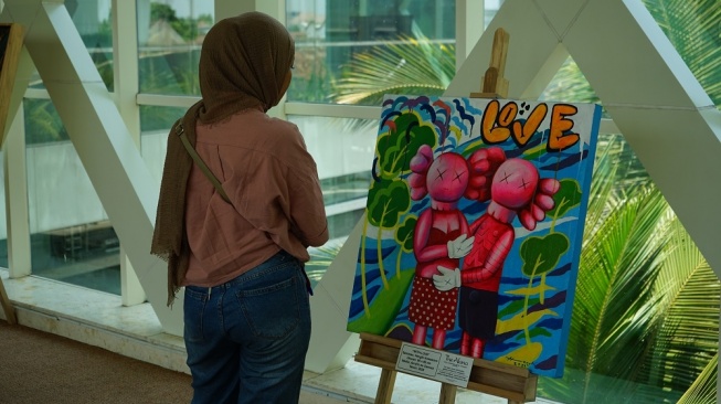 Seorang pengunjung menikmati salah satu karya seni yang mempercantik Sky Bridge di The Alana Yogyakarta Hotel & Convention Center, Selasa (5/9/2023). (Dok.Istimewa)