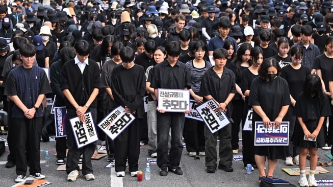 Para pengunjuk rasa mengheningkan cipta untuk seorang guru sekolah dasar yang meninggal karena bunuh diri pada bulan Juli lalu saat unjuk rasa menuntut perlindungan hak-hak guru di depan Majelis Nasional di Seoul, Korea Selatan, Senin (4/9/2023). [Yung Yeon-je / AFP]