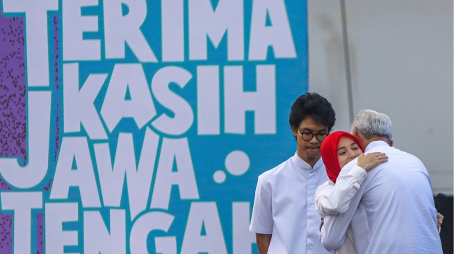 Gubernur Jawa Tengah Ganjar Pranowo (kanan) memeluk istrinya Siti Atiqoh Supriyanti (tengah) disaksikan putranya Zinedine Alam Ganjar (kiri) pada perpisahan bertajuk Pesta Rakyat Terima Kasih Jawa Tengah di Semarang, Jawa Tengah, Selasa (5/9/2023). [ANTARA FOTO/Aji Styawan/Spt]