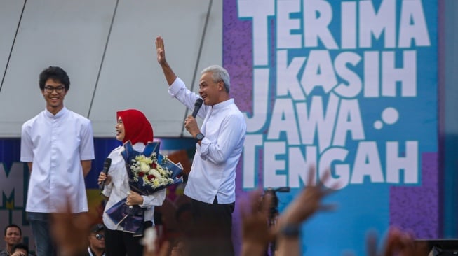 Gubernur Jawa Tengah Ganjar Pranowo (kanan) didampingi istrinya Siti Atiqoh Supriyanti (tengah) dan putranya Zinedine Alam Ganjar (kiri) menyapa warga pada perpisahan bertajuk Pesta Rakyat Terima Kasih Jawa Tengah di Semarang, Jawa Tengah, Selasa (5/9/2023). [ANTARA FOTO/Aji Styawan/Spt]
