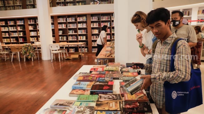 Pengunjung melihat buku saat acara Pasar Belanda di Kompleks Erasmus Huis, Jakarta, Minggu (10/9/2023). [Suara.com/Alfian Winanto]