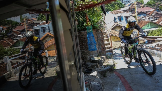 Pembalap sepeda melaju saat berusaha melewati lintasan di gang sempit dalam kejuaraan Gajahmungkur Ultimate Urban Downhill 2023 di Bendungan, Semarang, Jawa Tengah, Minggu (10/9/2023). [ANTARA FOTO/Makna Zaezar/YU]