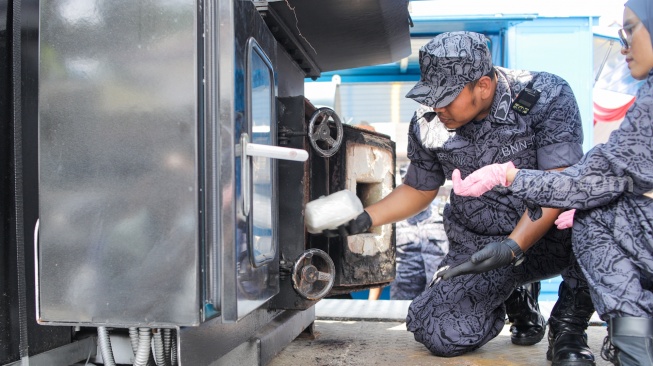 Petugas memasukkan barang bukti narkotika ke mesin pengahancur saat rilis kasus di Lapangan Kantor BNN RI, Jakarta, Selasa (11/9/2023). [Suara.com/Alfian Winanto]