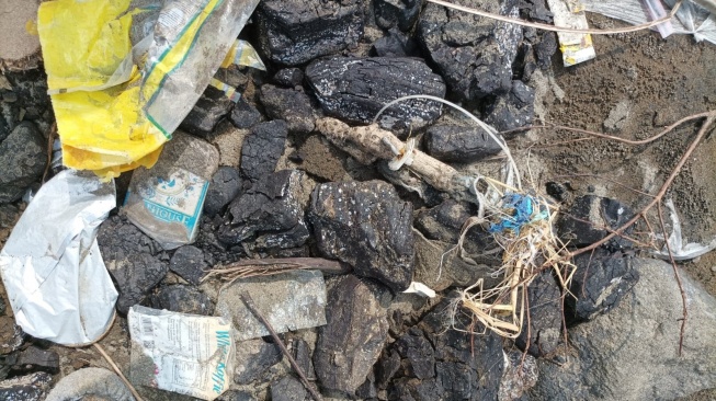 Tumpahan batu bara PLTU Pelabuhan Ratu di Pantai Batu Bintang, Sukabumi (30/4/2023). [Foto: Somad]