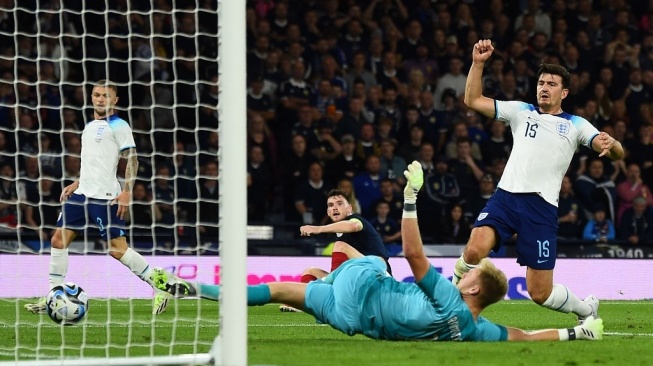 Bek Skotlandia Andrew Robertson (tengah) melakukan selebrasi saat bek Inggris Harry Maguire (kanan) mencetak gol bunuh diri pada pertandingan persahabatan internasional antara Skotlandia vs Inggris, di Hampden Park di Glasgow, pada 12 September 2023. Laga tersebut juga merupakan Pertandingan sepak bola 150th Anniversary Heritage, memperingati 150 tahun pertemuan pertama kedua tim, pada tanggal 30 November 1872.ANDY BUCHANAN / AFP.