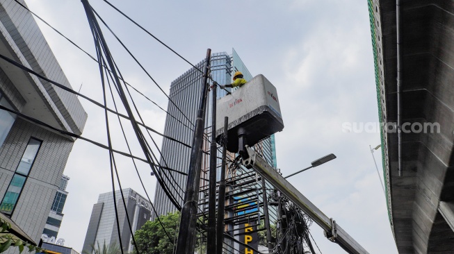 Petugas Dinas Bina Marga DKI Jakarta melakukan penataan kabel utilitas di sekitar Jalan Kapten Tendean, Jakarta, Kamis (14/9/2023). [Suara.com/Alfian Winanto]