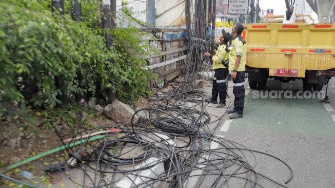 Petugas Dinas Bina Marga DKI Jakarta melakukan penataan kabel utilitas di sekitar Jalan Kapten Tendean, Jakarta, Kamis (14/9/2023). [Suara.com/Alfian Winanto]