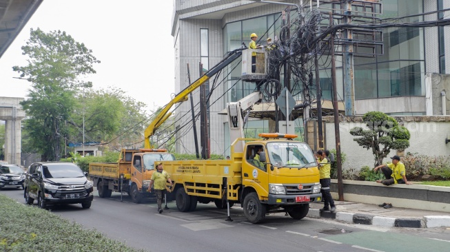 Petugas Dinas Bina Marga DKI Jakarta melakukan penataan kabel utilitas di sekitar Jalan Kapten Tendean, Jakarta, Kamis (14/9/2023). [Suara.com/Alfian Winanto]