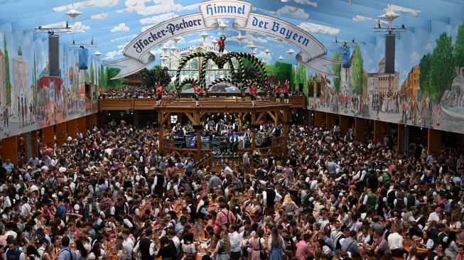 Orang-orang merayakan pembukaan festival Oktoberfest 2023 di Munich, Jerman, Sabtu (16/9/2023). [Christof STACHE / AFP]