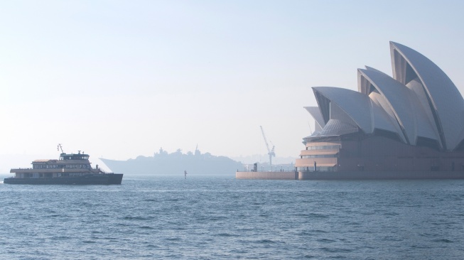 Penampakan Sydney Opera House yang diselimuti kabut asap di Sydney, Australia, Rabu (13/9/2023). [Steve CHRISTO / AFP]
