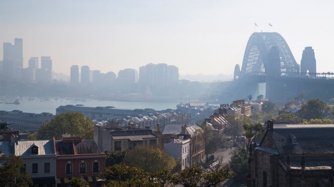 Penampakan Jembatan Pelabuhan Sydney yang diselimuti kabut asap di Sydney, Australia, Rabu (13/9/2023). [Steve CHRISTO / AFP]