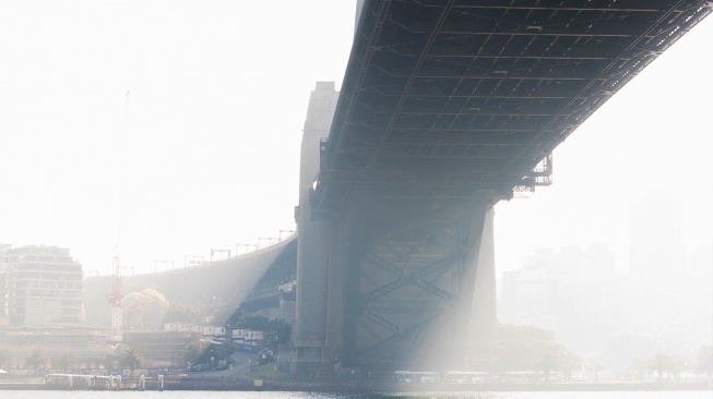 Penampakan Jembatan Pelabuhan Sydney yang diselimuti kabut asap di Sydney, Australia, Rabu (13/9/2023). [Steve CHRISTO / AFP]