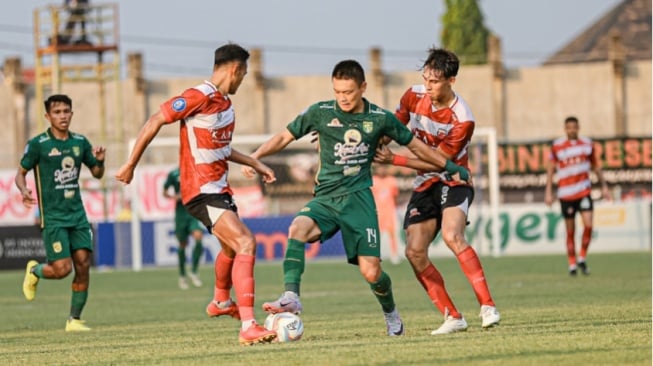 Gelandang Persebaya, Sho Yamamoto (tengah) saat berduel dengan pemain Madura United. (persebaya.id)