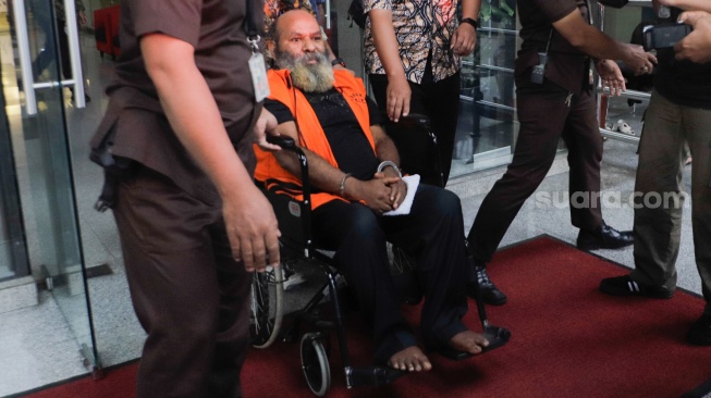 Tersangka mantan Gubernur Papua Lukas Enembe mengenakan kursi roda usai menjalani pemeriksaan di Gedung Merah Putih KPK, Jakarta, Selasa (19/9/2023). [Suara.com/Alfian Winanto]