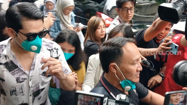 Pemeran pria film Keramat Tunggak, Fatra Ardianata (kaca mata hitam) jelang pemeriksaan di Polda Metro Jaya, Jakarta, Selasa (19/9/2023). [Suara.com/Adiyoga Priyambodo]