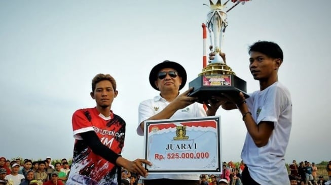 Menteri Koperasi dan Usaha Kecil dan Menengah RI Teten Masduki menyerahkan piala ke pemenang lomba merpati balap tingkat nasional. (Setda Kabupaten Tegal)