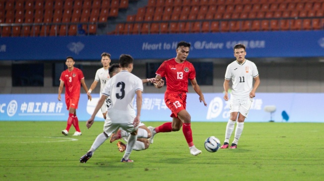 Gelandang Timnas Indonesia U-24, Rachmat Irianto menggiring bola ketika ditempel ketat pemain Kirgistan U-24 dalam matchday pertama Grup F Asian Games 2022 di Zhejiang Normal University East Stadium, Zhejiang, China, Selasa (19/9/2023) malam WIB. [Dok. PSSI]