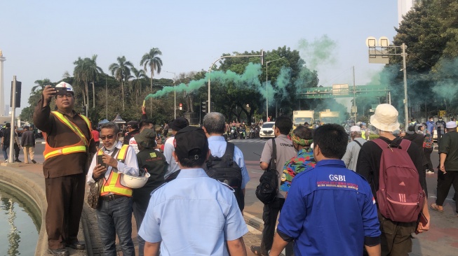 Aksi 209 Bela Rempang di kawasan Patung Kuda Jakarta Pusat diwarnai smoke bomb atau bom asap yang dilakukan seorang pendemo. (Suara.com/Faqih)