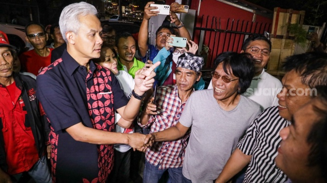 Bacapres PDI Perjuangan Ganjar Pranowo (kiri) disambut oleh Sekjen Persatuan Nasional Aktivis 98 Adian Napitupulu (kanan) saat berkunjung ke Graha Pena 98, Jakarta, Kamis (21/9/2023). [Suara.com/Alfian Winanto]