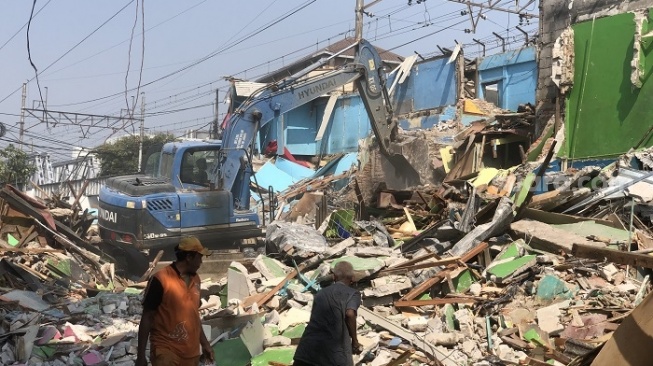 Petugas merobohkan bangunan dengan menggunakan alat berat di lokalisasi Gang Royal di Penjaringan, Jakarta Utara. (Suara.com/Faqih)