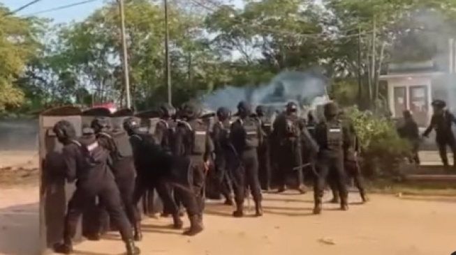 Aparat kepolisian saat menembakan gas air mata ke massa saat demo ricuh di Seruyan Kalteng. (tangkapan layar/ist)