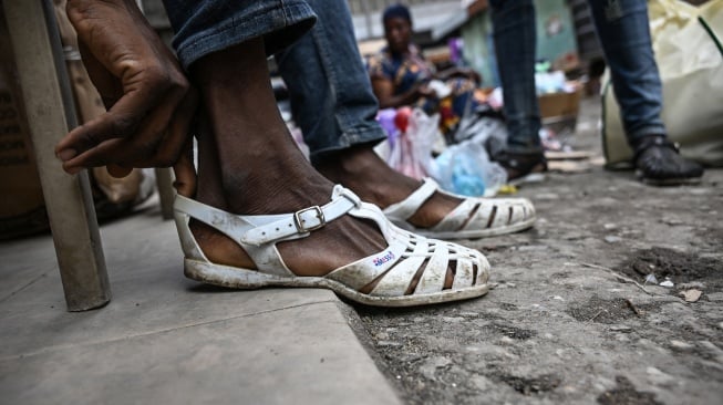 Seorang pria memakai sandal Leke di Treichville, Abidjan, Pantai Gading, Kamis (14/9/2023). [Sia KAMBOU / AFP]
