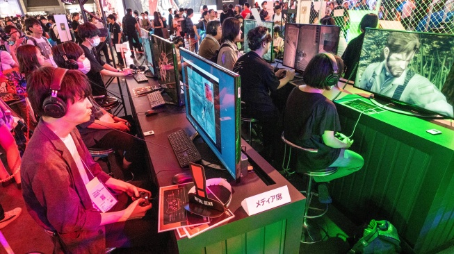 Pengunjung bermain video game saat menghadiri gelaran Tokyo Game Show 2023 di Makuhari Messe, Prefektur Chiba, Jepang, Kamis (21/9/2023). [Richard A. Brooks / AFP]