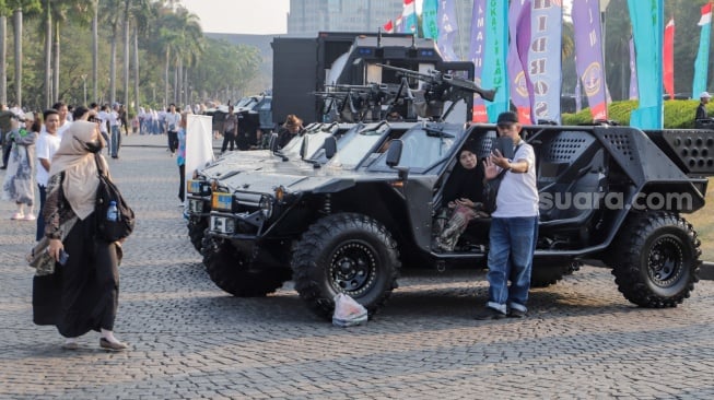 Sejumlah warga melihat pameran alutsista di kawasan Monas, Jakarta, Senin (25/9/2023). [Suara.com/Alfian Winanto]