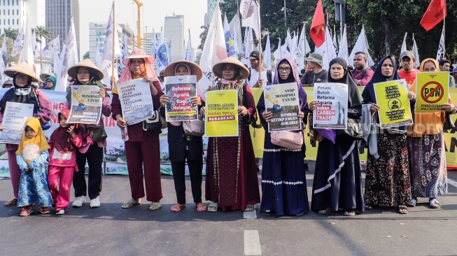 Massa yang tergabung dalam Komisi Nasional Pembaruan Agraria (KNPA) melakukan aksi dalam puncak acara Peringatan Hari Tani Nasional 2023 di kawasan Patung Kuda, Jakarta, Selasa (26/9/2023). [Suara.com/Alfian Winanto]
