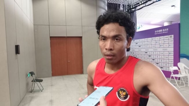 Sprinter Indonesia Lalu Muhammad Zohri menjawab pertanyaan pewarta di mixed zone Hangzhou Olympics Sports Centre, Hangzhou, setelah mengikuti heat 5 lari 100 meter putra, Jumat (29/9/2023). (ANTARA/RAUF ADIPATI)