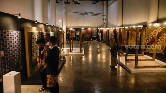 Pengunjung melihat koleksi kain batik di Museum Batik Indonesia, Taman Mini Indonesia Indah, Jakarta, Senin (2/10/2023). [Suara.com/Alfian Winanto]