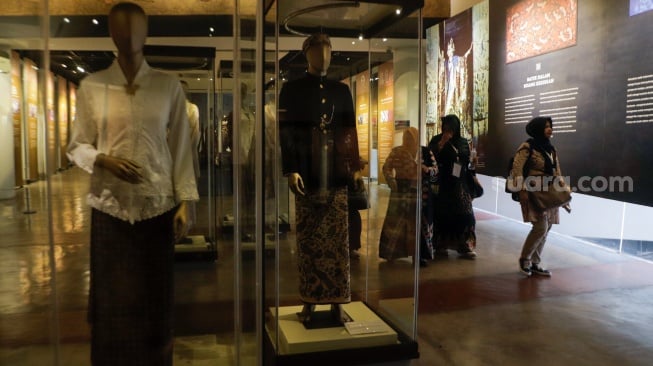 Pengunjung melihat koleksi kain batik di Museum Batik Indonesia, Taman Mini Indonesia Indah, Jakarta, Senin (2/10/2023). [Suara.com/Alfian Winanto]