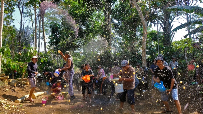 Warga saling menyiram minuman dawet cendol saat tradisi Perang Dawet Cendol untuk meminta hujan di tengah perkebunan kopi Desa Kemiriombo, Gemawang , Temanggung, Jateng, Jumat (6/10/2023). [ANTARA FOTO/Anis Efizudin/nym]