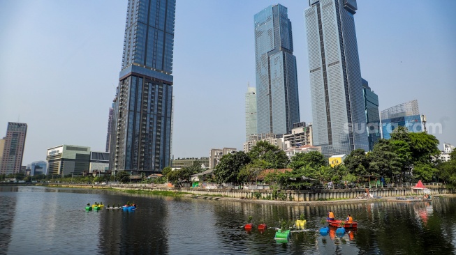 Petugas menyiram tanaman yang ada di dalam Pot Apung di Waduk Melati, Jakarta, Jumat (6/10/2023). [Suara.com/Alfian Winanto]