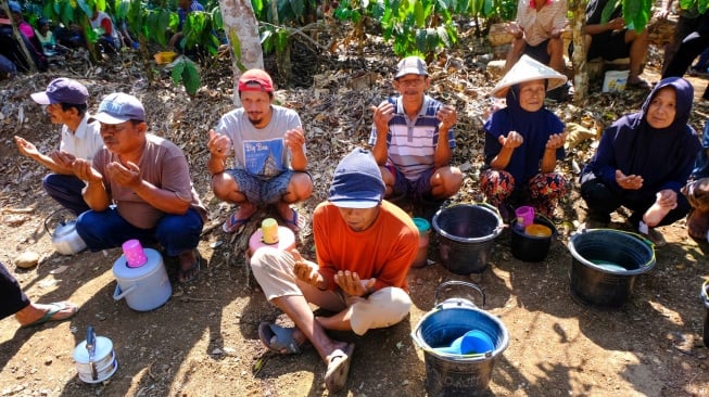 Warga berdoa bersama saat tradisi Perang Dawet Cendol untuk meminta hujan di tengah perkebunan kopi Desa Kemiriombo, Gemawang , Temanggung, Jateng, Jumat (6/10/2023). [ANTARA FOTO/Anis Efizudin/nym]