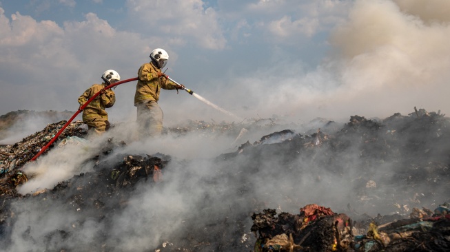 Petugas pemadam kebakaran melakukan pendinginan pada tumpukan sampah yang terbakar di tempat pembuangan akhir (TPA) Jatibarang Semarang, Jawa Tengah, Jumat (6/10/2023). [ANTARA FOTO/ANTARA FOTO/Aji Styawan/tom]