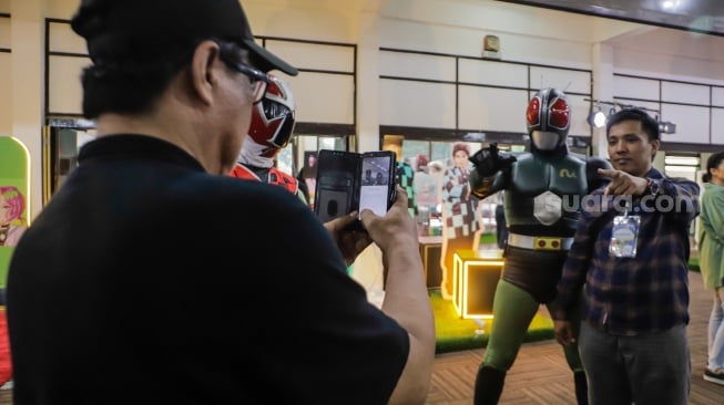 Pengunjung berswafoto dengan cosplayer di acara ANIMART Indonesia 2023 di Wisma Serbaguna GBK, Senayan, Jakarta, Sabtu (7/10/2023). [Suara.com/Alfian Winanto]