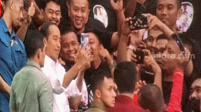 Pegang HP Relawan, Jokowi Ajak Foto Bareng di Acara Konsolidasi di Sentul