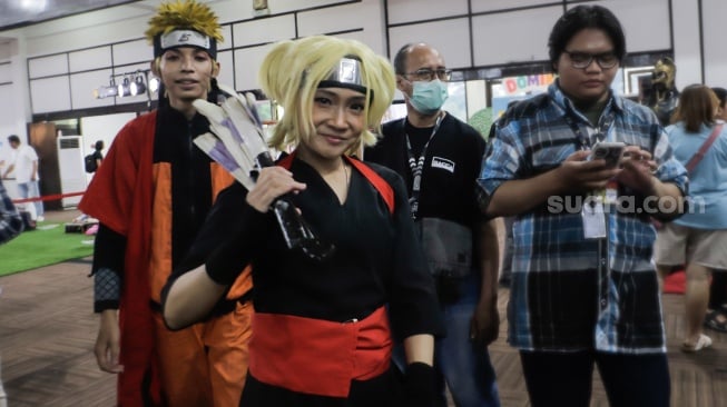 Cosplayer bergaya saat tampil di acara ANIMART Indonesia 2023 di Wisma Serbaguna GBK, Senayan, Jakarta, Sabtu (7/10/2023). [Suara.com/Alfian Winanto]