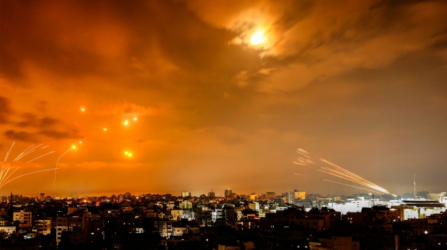 Roket yang ditembakkan militan Palestina dicegat oleh sistem rudal pertahanan Iron Dome Israel di Kota Gaza, Palestina, Minggu (8/10/2023). [EYAD BABA / AFP]