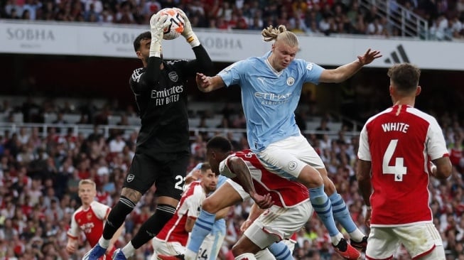 Kiper Arsenal, David Raya menangkap bola di bawah tekanan striker Manchester City Erling Haaland selama pertandingan pekan ke-9 Liga Inggris 2023-2024 antara Arsenal vs Manchester City di stadion The Emirates di London pada 8 Oktober 2023.Ian Kington / IKIMAGES / AFP.