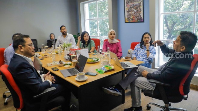 Pemimpin Redaksi Suara.com, Suwarjono (kanan) memberikan pemaparan saat menerima kunjungan dari rekan-rekan mitra media regional International Media Supports (IMS) di Kantor Suara.com, Jakarta, Selasa (10/10/2023). [Suara.com/Alfian Winanto]