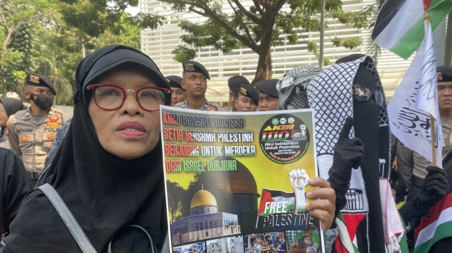 Seorang emak-emak ikut aksi solidaritas untuk Palestina di depan Kedubes Amerika Serikat, Jakarta. (Suara.com/Faqih)