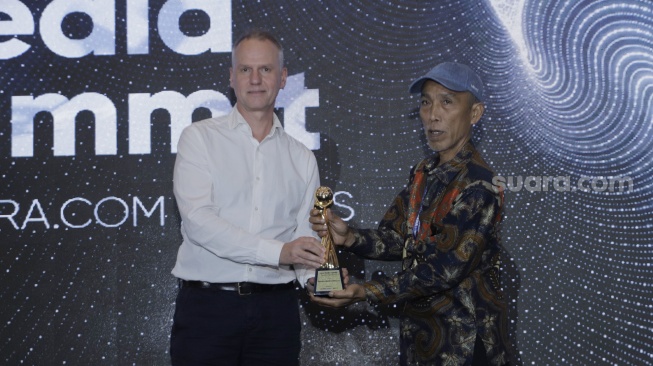 IMS Asia Regional Director Mr. Lars Bestle memberikan penghargaan kepada CEO Sukabumi Update Nuril Arifin saat Local Media Summit 2023 yang berlangsung di Hotel Aryaduta, Jakarta Pusat pada Rabu, (11/10/2023). [Suara.com/Alfian Winanto]