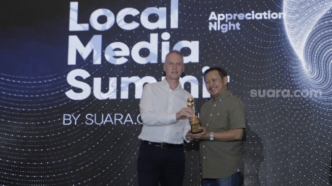 IMS Asia Regional Director Mr. Lars Bestle memerikan penghargaan kepada Pemimpin Umum & Pemimpin Redaksi Beritajatim.com Dwi Eko Lokononto saat Local Media Summit 2023 di Hotel Aryaduta, Jakarta Pusat pada Rabu, (11/10/2023). [Suara.com/Alfian Winanto]