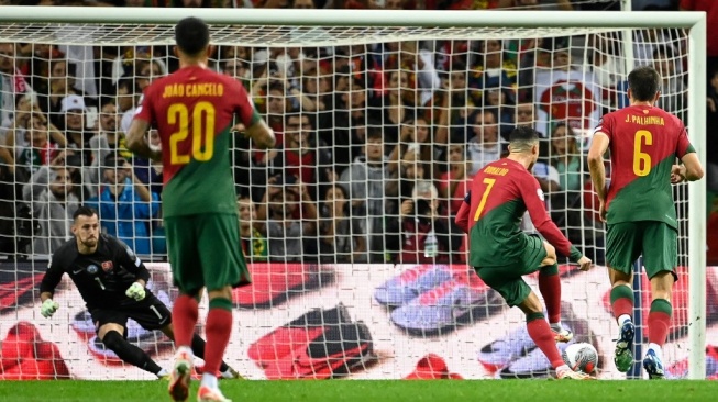 Penyerang Portugal Cristiano Ronaldo melakukan tendangan penalti dan mencetak gol kedua timnya selama pertandingan sepak bola kualifikasi grup J putaran pertama EURO 2024 antara Portugal dan Slovakia di stadion Dragao di Porto pada 13 Oktober 2023.MIGUEL RIOPA / AFP