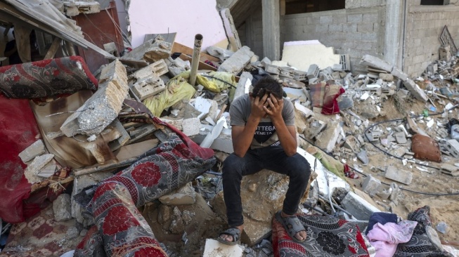 Seorang pemuda di Kota Gaza terduduk di puing-puing reruntuhan akibat serangan militer Israel. (Foto: AFP)