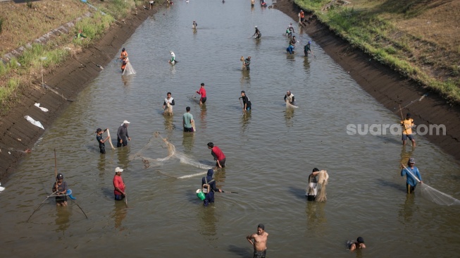 Warga mencari ikan memanfaatkan ditutupnya saluran irigasi Bendungan Colo di Nguter, Sukoharjo, Jawa Tengah, Senin (16/10/2022). [ANTARA FOTO/Mohammad Ayudha/tom]