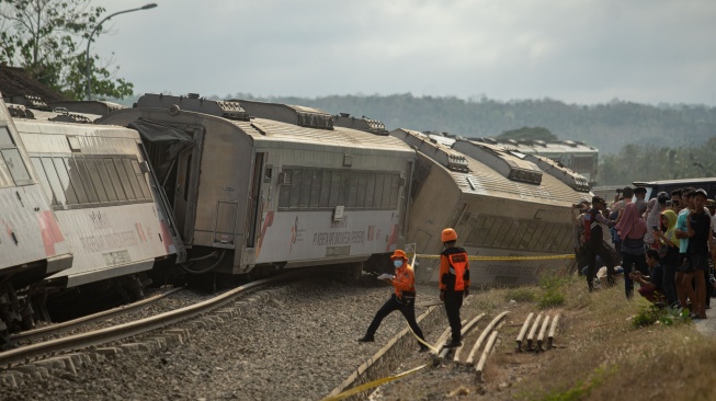 Petugas melakukan penangananan di dekat gerbong kereta api yang anjlok akibat kecelakaan di kawasan Kalimenur, Sukoreno, Kulonprogo, D.I Yogyakarta, Selasa (17/10/2023). [ANTARA FOTO/Andreas Fitri Atmoko].