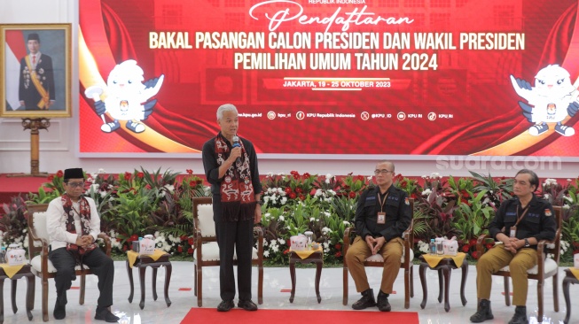 Bakal calon Presiden Ganjar Pranowo (kedua kiri) bersama bakal calon Wakil Presiden Mahfud MD (kiri) saat melakukan pendaftaran Calon Presiden dan Wakil Presiden Pemilihan Umum 2024 di Gedung KPU, Jakarta, Kamis (19/10/2023). [Suara.com/Alfian Winanto]
